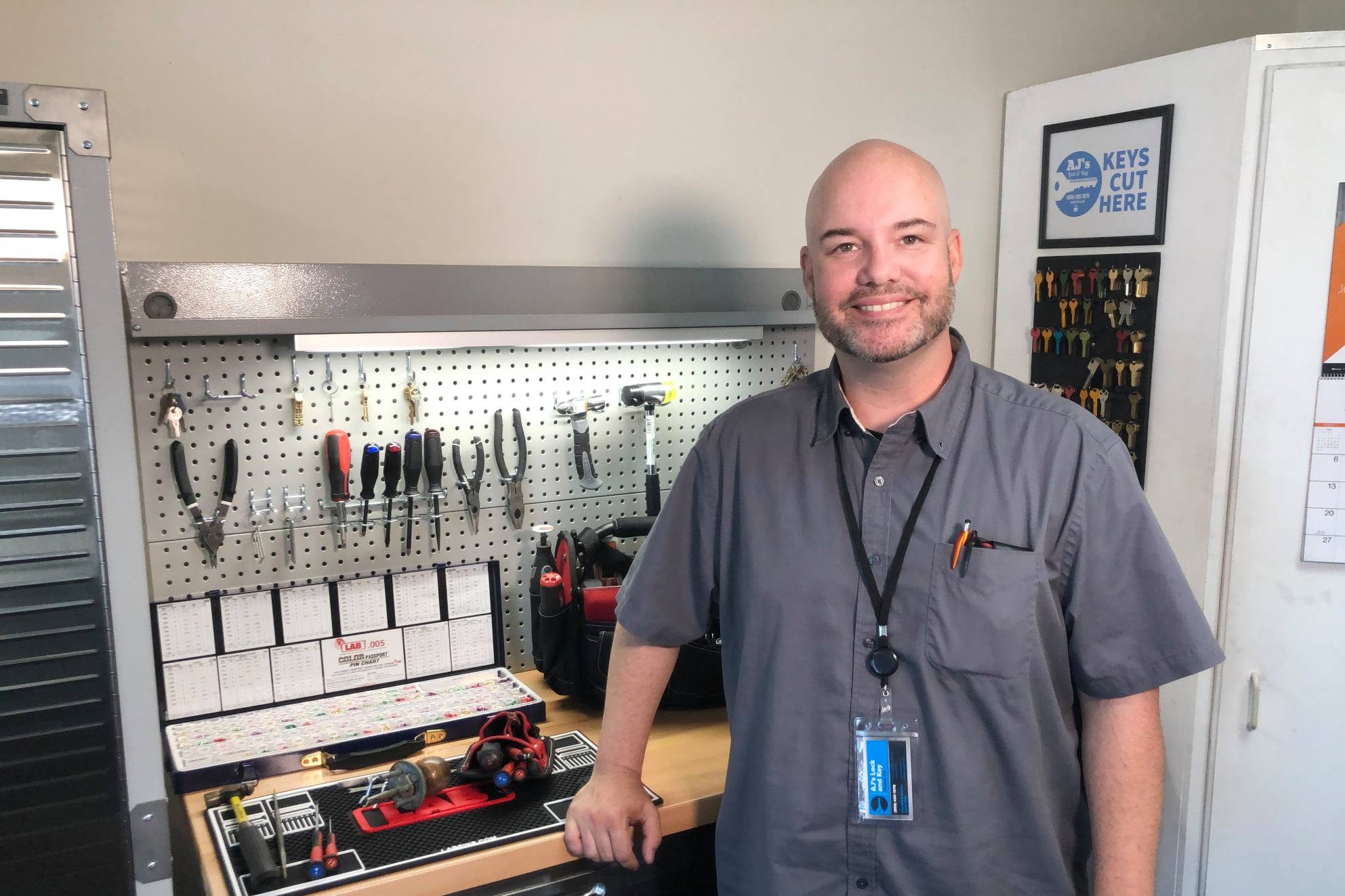 Alex Buntin at his fully equipped locksmith workbench with professional tools and key blanks