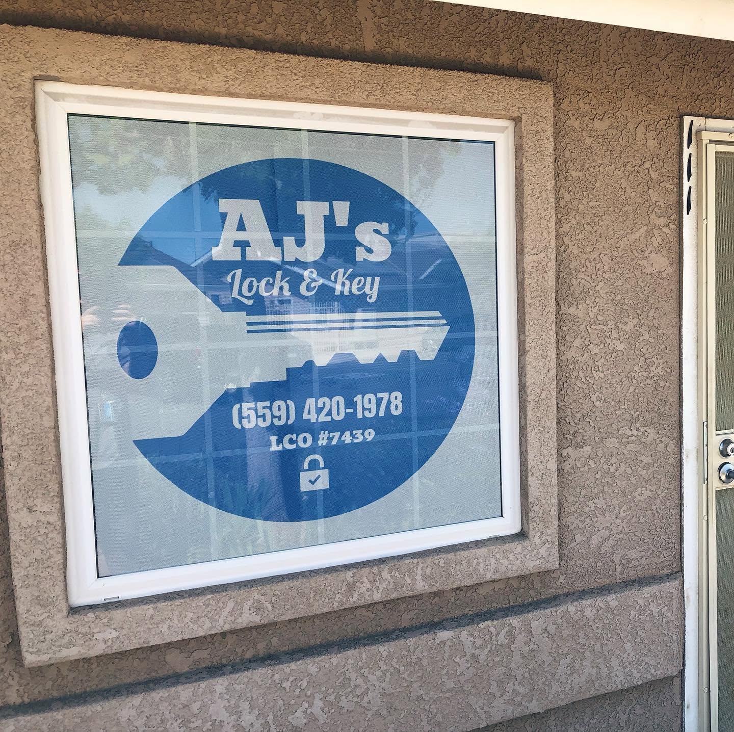 AJ's Lock & Key branded window sign showing (559) 420-1978 and LCO #7439